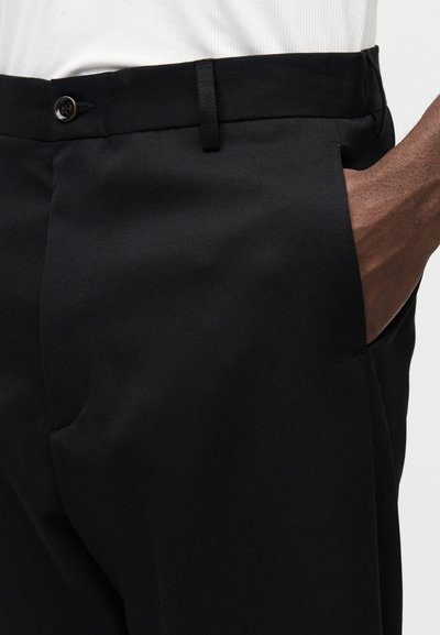 Pantaloni negri realizați dintr-un material neted, cu închidere cu nasture și buzunar lateral. Croială ajustată cu un design elegant și curat.