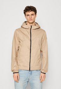 Beige lightweight jacket with a zip front, a hood, and elastic cuffs. Designed with a smooth texture and contrasting black zipper.
