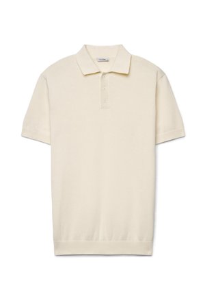 Polo crème à manches courtes avec patte de boutonnage à trois boutons et col, poignets et ourlet côtelés, présenté sur fond blanc.