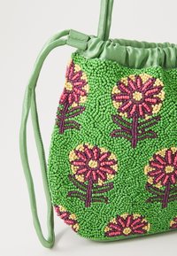 Grüne Perlenhandtasche mit floralem Design, das rosa und gelbe Blumen zeigt. Mit Kordelzugverschluss und schmalem, passendem Schulterriemen. Strukturierte Oberfläche.