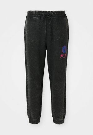 Schwarze Sweatpants mit strukturiertem Finish, ausgestattet mit einem Kordelzugbund, seitlichen Streifen und einem bunten Grafikdesign am linken Oberschenkel.