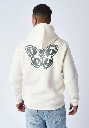 Sudadera crema con un gran gráfico de mariposa negra en la parte posterior, bolsillo tipo canguro y capucha con cordón; hecha de una suave tela texturizada.