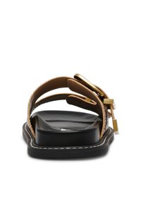 Brun lædersandal med dobbelte stropper og detaljer i guldhardware, med en sort sål og hvid syning samt en glat overflade.
