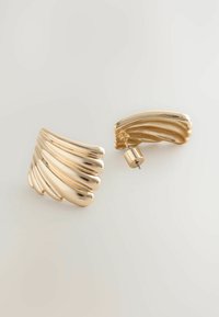 Guldfarvede metaløreringe med et bølget, ribbet design. Har glatte og skinnende overflader, næsten cirkulære studs til sikker fastgørelse.