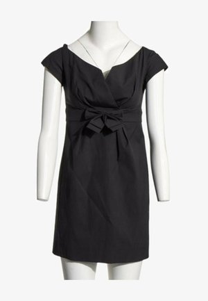 Robe noire à manches courtes avec un décolleté en V et un nœud en tissu noué à la taille, présentée sur un mannequin blanc.