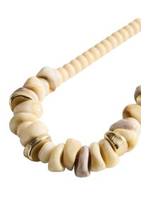 Collier en perles avec des pierres de couleur crème, de formes irrégulières, et des accents dorés, monté sur un cordon torsadé beige.