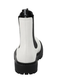 Botas Chelsea con parte superior de cuero blanco, paneles laterales elásticos negros, suela negra resistente y una lengüeta trasera con el logotipo.