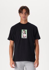 Zwarte katoenen t-shirt met een grafische print van een vrouw die een spiegel vasthoudt en de tekst "VOLCOM" aan de onderkant. Korte mouwen, comfortabele pasvorm.