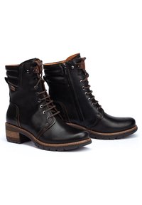 Svarta läderankelstövlar med snörning framtill, sidodragkedja, klack med staplad design och tan-färgade detaljer. Slät textur, robust sula och stilig sömnad.