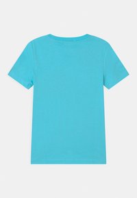 Koszulka z krótkim rękawem, okrągłym dekoltem w jasnoniebieskim kolorze, wykonana z bawełny. Gładka faktura z przeszytymi brzegami i bez widocznych wzorów czy grafik.