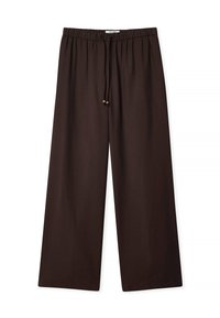 Braune, weit geschnittene Hosen aus weichem Stoff mit elastischem Bund und Zugband, das an den Enden mit zwei Holzperlen verziert ist.