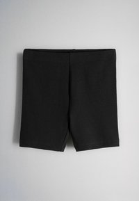 Pantalones cortos de tela acanalada negra con cintura elástica, mostrados planos sobre un fondo gris claro.