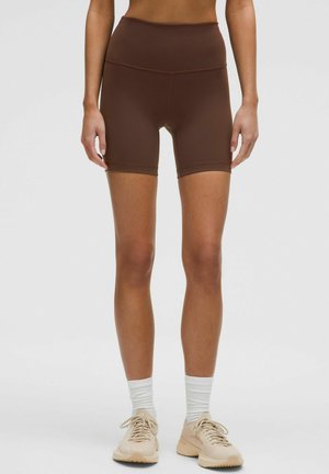 Brune atletiske shorts med høj talje, lavet af glat, strækbart materiale. Kendt for deres længde til midt på låret og sømløse design.