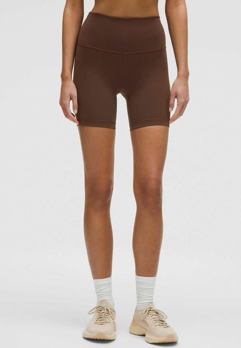 Hnedé športové šortky s vysokým pásom, vyrobené z hladkého, elastického materiálu. Významné sú svojou dĺžkou do polovice stehien a bezšvovým prevedením.