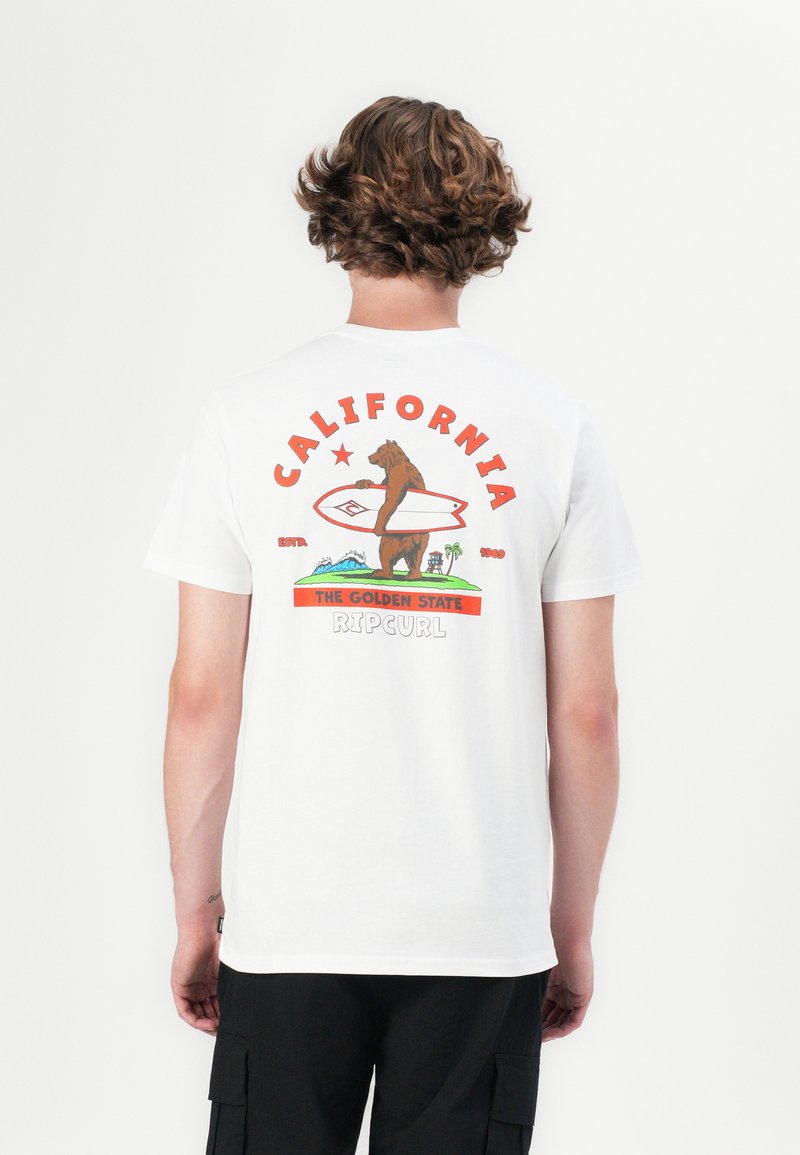 Hvid bomulds t-shirt med et farverigt grafik af en brun bjørn, der holder et surfbræt, med tekstelementerne "CALIFORNIA" og "RIPCURL".