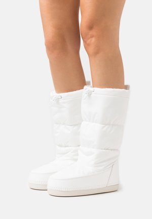 Bottes blanches isolées avec une tige haute et gonflée ; texture lisse ; cordon de serrage réglable ; semelle plate beige avec détails de couture.