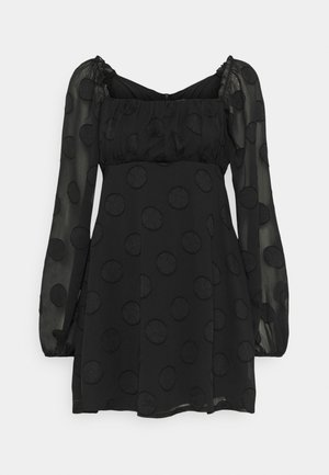 Vestido corto negro con mangas largas abullonadas de tul y patrón de lunares texturizados, escote cuadrado y cuerpo fruncido.