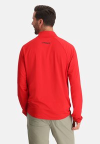 Rotes Langarm-Performance-Shirt mit strukturiertem Finish und Kragen. Es verfügt über ein kleines schwarzes "Spyder"-Logo auf der Rückseite.