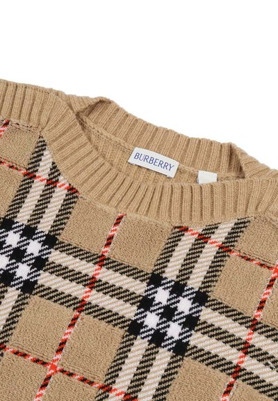 Maglione lavorato a maglia beige con un motivo a quadri distintivo caratterizzato da accenti neri, bianchi e rossi. Collo rotondo a costine, etichetta visibile.