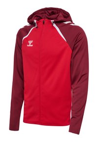 Felpa rossa con zip e cappuccio regolabile, maniche bordeaux a contrasto, dettagli bianchi e logo Hummel in alto a sinistra.
