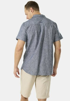 Korte mouwen, blauwe, gestructureerde shirt met een button-down kraag en logo-detail op de achterkant, gecombineerd met beige shorts. Casual en lichtgewicht.