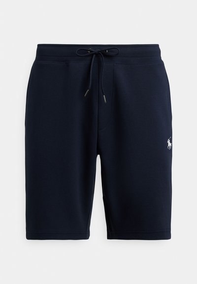 Granatowe, bawełniane spodenki sportowe z elastycznym paskiem, sznurkiem do wiązania oraz logo po lewej stronie. Gładka faktura, długość do kolan.