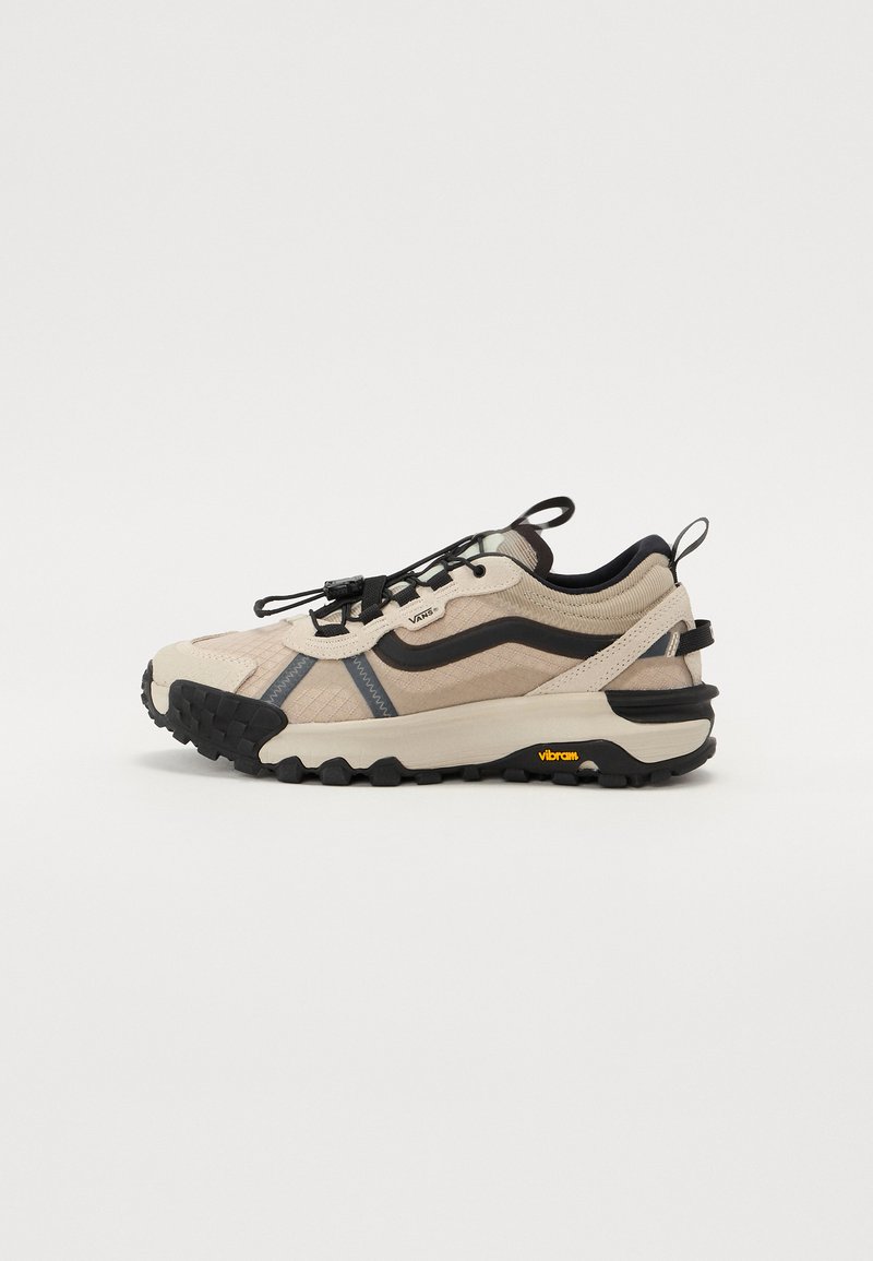 Ljusbeige vandringsskor med svarta detaljer, strukturerat mönster, elastiskt snörsystem och Vibram-sula för bra grepp. Gummibeklätt häl och logotypdetalj.