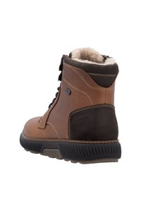 Bottine en cuir marron avec un panneau en suède marron foncé, dotée d'une doublure en fourrure douce, d'une semelle en caoutchouc texturée et de lacets noirs.