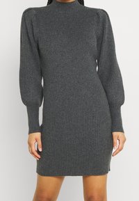 Vestito a maglia grigio a coste con collo alto, maniche lunghe a palloncino e silhouette aderente, caratterizzato da una morbida texture e lunghezza fino a metà coscia.