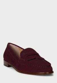 Burgundy suede loafer with a stitched accent and a flat wooden heel, featuring a decorative top panel and a smooth, textured finish.