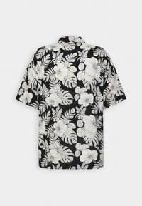 Chemise noire à manches courtes avec imprimé floral et feuilles tropicales blanches, montrant la vue de dos sur un fond neutre.