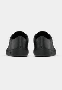 Schwarze Lederschuhe mit einer glatten Textur, runder Form, flachem Profil und einfachem Design. Sie verfügen über gestickte Akzente und Gummisohlen.