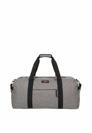 Sac de sport en tissu gris avec poignées noires et poche zippée à l’avant, avec un petit écusson logo Eastpak sur le devant.