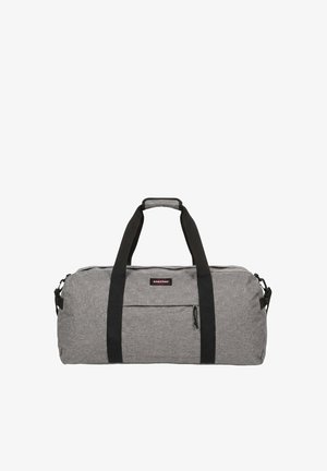 Sac de sport en tissu gris avec poignées noires et poche zippée à l’avant, avec un petit écusson logo Eastpak sur le devant.