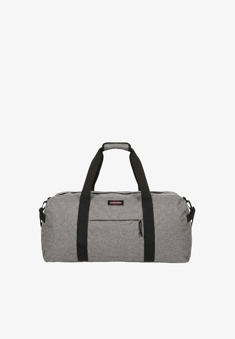 Sac de sport en tissu gris avec poignées noires et poche zippée à l’avant, avec un petit écusson logo Eastpak sur le devant.