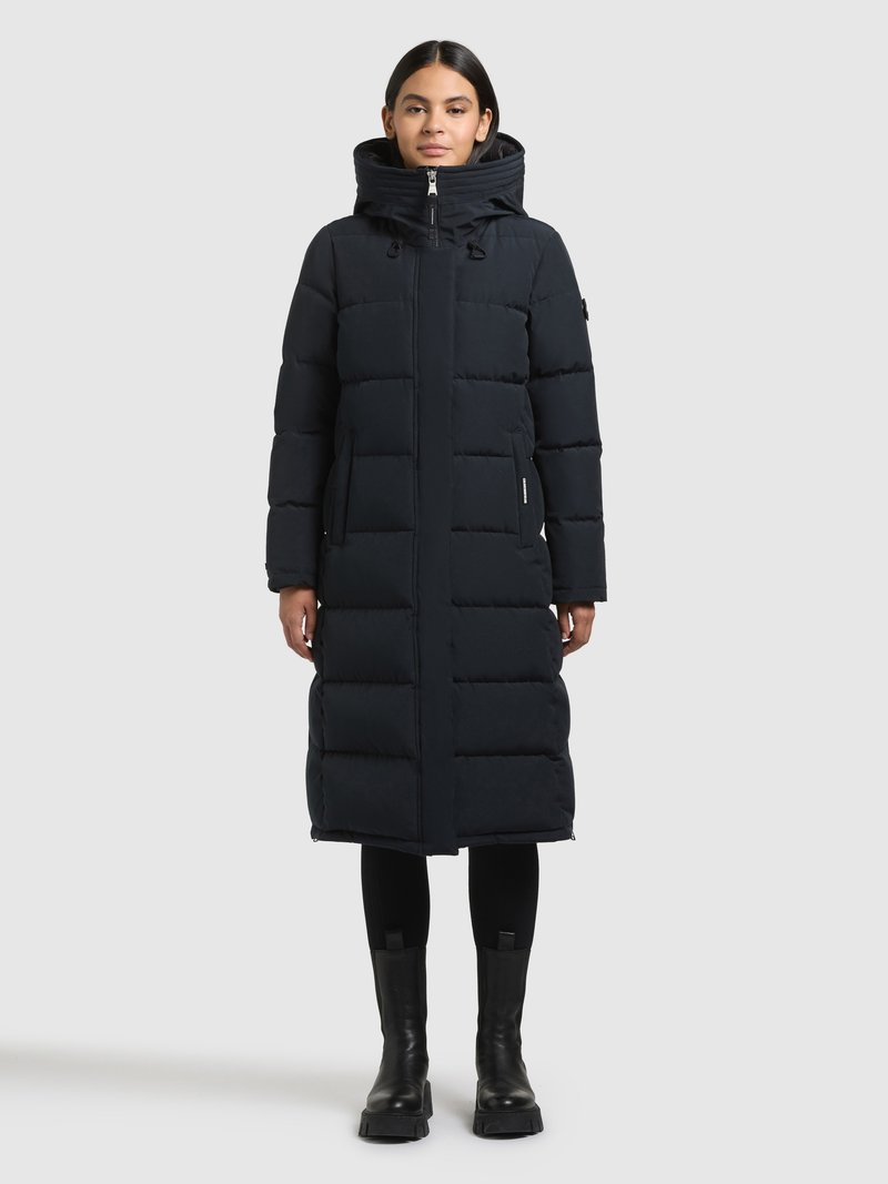 Abrigo largo azul marino acolchado con cuello alto, cremallera frontal y dos bolsillos laterales. Textura lisa con patrón acolchado cuadriculado.