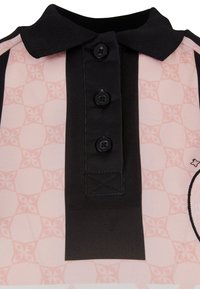 Polo majica s ovratnikom, ki je izdelana iz pinko vzorčaste tkanine, s črnimi detajli, tremi gumbi in teksturiranim dizajnom na eni strani.