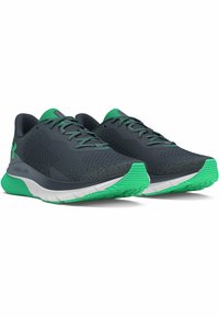 Zapatillas deportivas de un gris oscuro con detalles en verde, que cuentan con una parte superior transpirable, un collar acolchado y una suela texturizada para mayor tracción.
