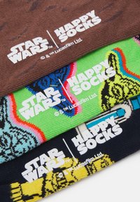 Tričko páry ponožiek: hnedé so vzorom, zelené s farebnými dizajnmi a čierne s podrobnou postavičkou, všetky značky "Happy Socks."