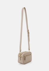 Borsa a tracolla rettangolare beige realizzata in materiale sintetico liscio, con hardware in tonalità dorata, doppie tasche con zip e tracolla regolabile.