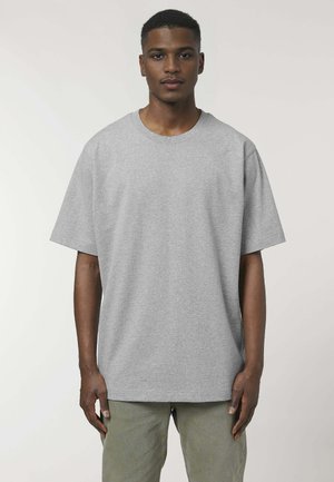 Grijze katoenen oversized t-shirt met korte mouwen en een ronde halslijn, getoond op een model. De stof heeft een gladde textuur.