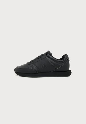 Sort lavtop lædersneaker med snøre, teksturerede og glatte paneler, flad sål og subtil "cK" logo på siden.