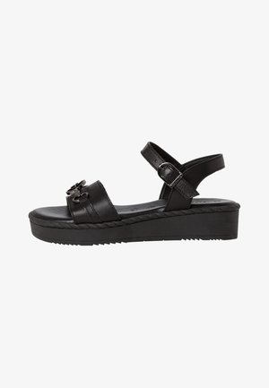 Black leather platform sandals with an adjustable buckle, featuring a wide strap and decorative hardware on the front. Textured sole.