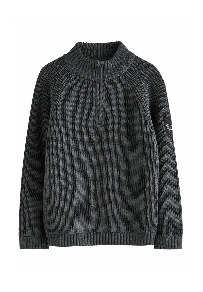 Pull en tricot gris foncé avec un col haut, fermeture éclair sur le devant et poignets côtelés. Présente une texture verticale et un écusson sur la manche gauche.