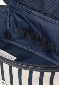 Borsa cosmetica a strisce con esterno crema e strisce navy, dotata di una tasca a rete interna e anelli elastici per l'organizzazione.