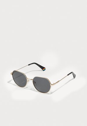 Gold metal sunglasses with gray lenses, an octagonal shape, thin temples, and a multicolored striped detail on the inner arm.