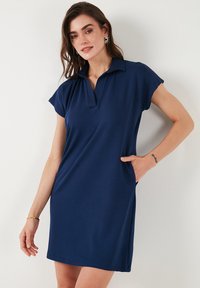 Námornícky modré polo šaty s golierom, krátkymi rukávmi, bočnými vreckami a voľným strihom vyrobené z hladkej, ľahkej tkaniny.