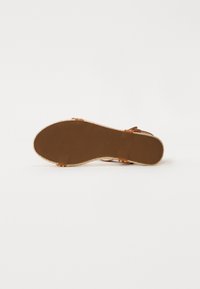 Sandale espadrile maro cu un branț de cauciuc texturat, o talpă intermediară din jute împletit și curele ajustabile cu accente metalice.