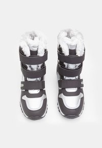 Sorte og sølv sneboot med to velcro-stropper, fluffy hvid foring øverst og robuste sorte såler til trækkraft.