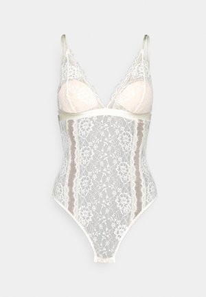 Csipkés bodysuit áttetsző fehér virágmintával, puha bézs kosarakkal, állítható pántokkal, és varrás nélküli hátrésszel a tökéletes illeszkedésért.